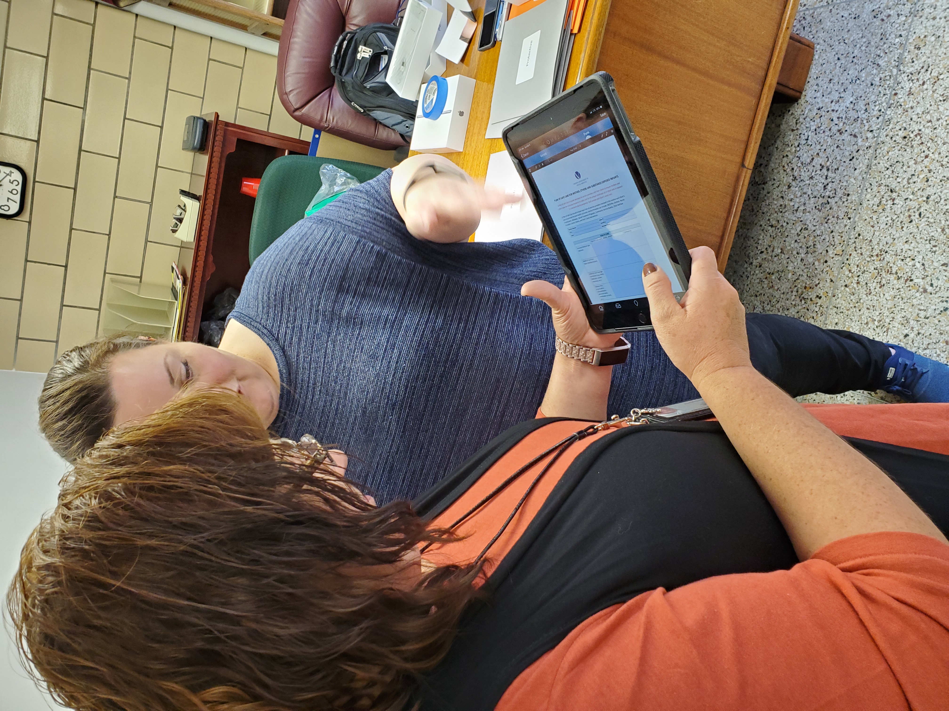 two women looking at ipad