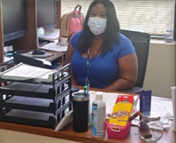 woman at her desk with a mask on