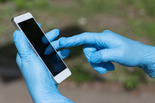 gloved hands with mobile phone