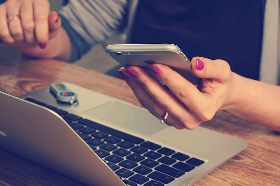 computer with woman holding a cell phone